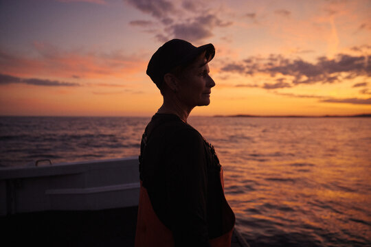 The captain of a fishing boat looking to the sea during evening hours