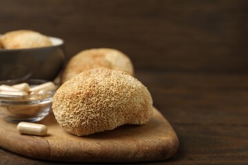 Functional mushrooms and pills on wooden table, closeup. Space for text © New Africa