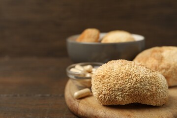 Functional mushrooms and pills on wooden table, closeup. Space for text © New Africa