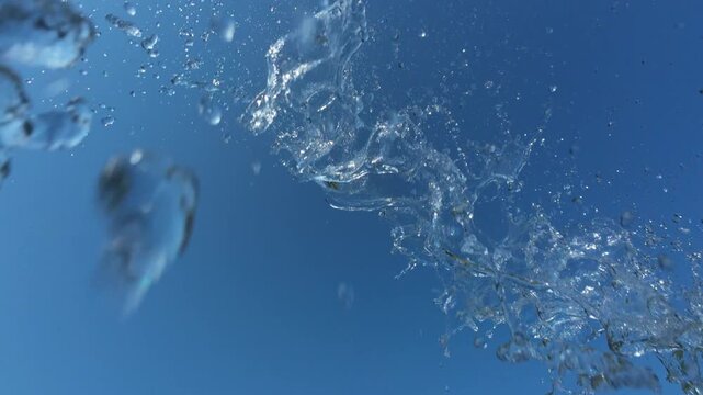 Water Splash Spraying From Above Against Clear Blue Sky with Birds in Background
