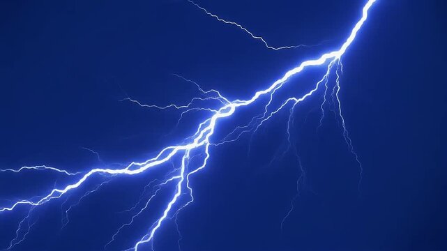 Bright white lightning bolt strikes down against a dark blue night sky.