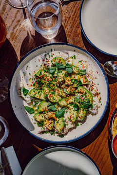 Mediterranean fish crudo with avocado slices and pickled onion