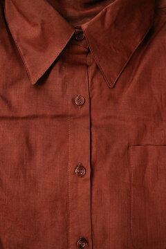 Close-up Shot of Folded Terracotta Button-Up Shirt 