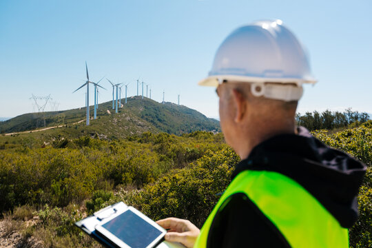 Engineer inspecting wind farm for renewable energy production