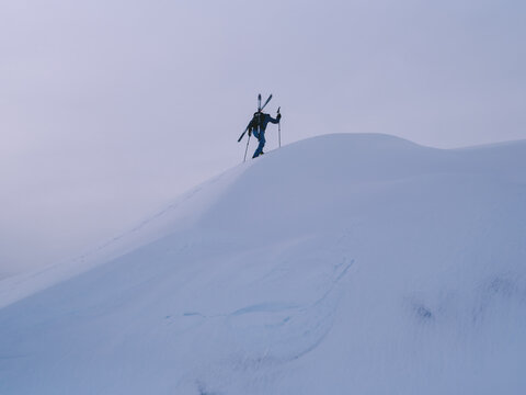 Winter Backcountry Skier Climbing Steep Ridge