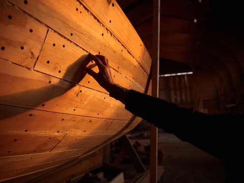 Woodworking process of a boat in a workshop during evening light