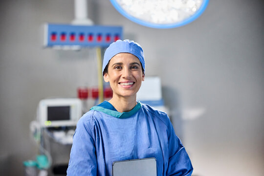 A healthcare professional smiles confidently in surgical attire
