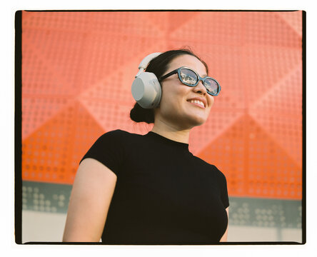 Young Woman Listening to Music in Wireless Headphones