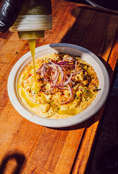 Chef pouring olive oil over a Peruvian ceviche