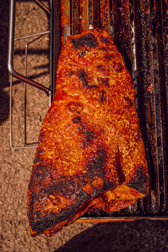 Large piece of grilled pork ribs smoking on a barbecue
