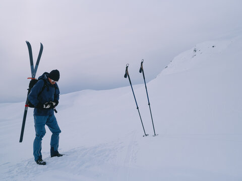 Winter Backcountry Skier Adjusting Gear on Snow Slope