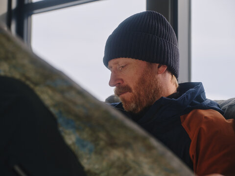 Man Studying a Topographic Map Indoors