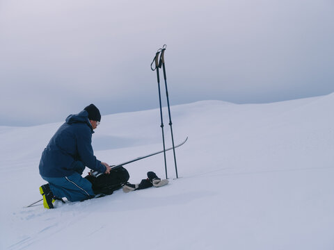 Nordic Backcountry Skier Preparing Equipment for Ascent