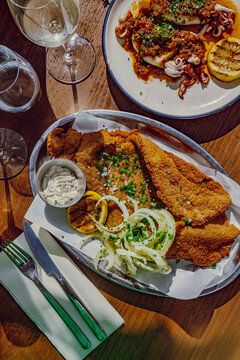 Mediterranean restaurant table with meat milanesa and grilled octopus
