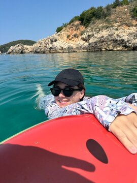 Woman relaxing on inflatable ring in crystal clear turquoise sea
