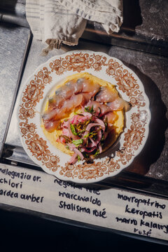 Gourmet Mediterranean raw fish crudo over yellow polenta base