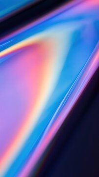 Iridescent foil texture with vibrant rainbow reflections and a liquid-like sheen. Electric blue and pastel pink hues create a glossy, futuristic abstract background.