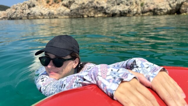 Woman relaxing on inflatable ring in crystal clear turquoise sea