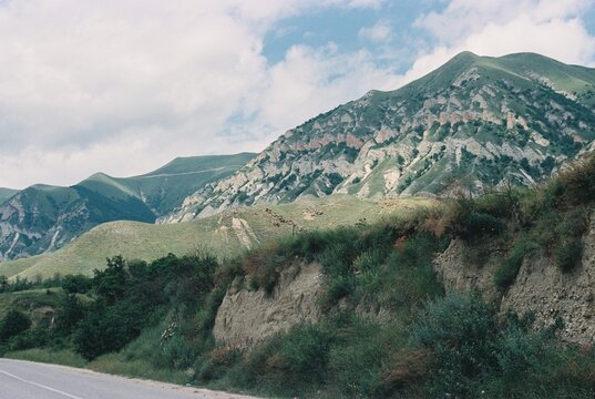 Majestic Mountains Rise Under a Blue Sky With Fluffy Clouds