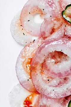 Marinated Onion Rings With Black Pepper And Chili Oil Along One Edge Of A White Frame