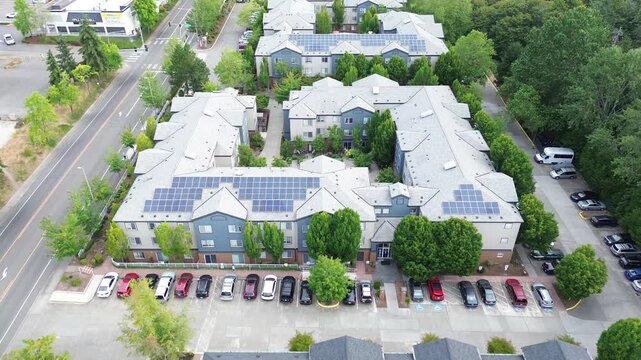 Rooftop photovoltaic arrays absorb sunlight along Pete von Reichbauer Way S, resting above parking stalls, highlighting eco friendly residential infrastructure investments in Federal Way, WA
