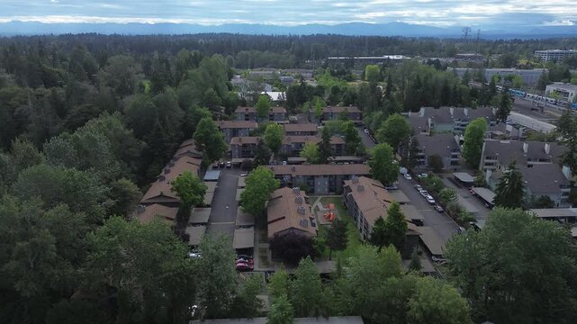 Dense evergreen trees frame Pete von Reichbauer Way S, where multi family complexes emerge amidst woodlands, capturing urban residential density alongside Cascade foothills in Federal Way, WA
