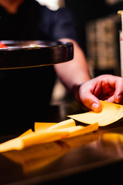 BRAZO DE UN COCINERO ESTA TOMANDO UN PEDIDO Y SOSTENIENDO UN PLATO