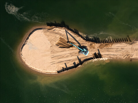 Aerial view of an excavator working on the sandy shore of Lampedziai Beach in Kaunas, Kauno apskritis, Lithuania.
