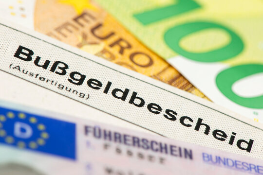 Ein Bu&szlig;geldbescheid liegt zusammen mit einem F&uuml;hrerschein und Euro Geldscheinen