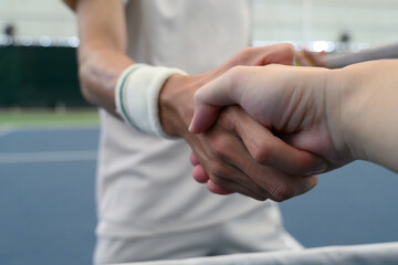 Fototapeta premium Close Up of Tennis Players Shaking Hands at the Net After Match on Indoor Court