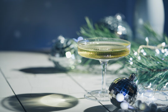 Christmas and New Year celebration with champagne. New Year holiday decorated table. Festive New Year champagne and silver baubles. Close up. Christmas greeting card with copy space.