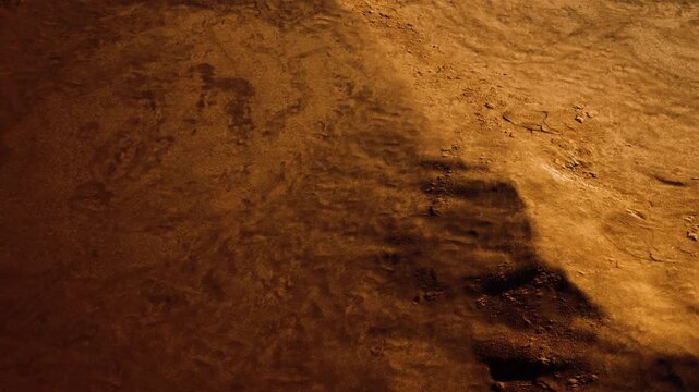 Sand forms patterns under the fading light of day. The warm hues of sunset reflect on the ripples and textures of the surface. This scene shows natures artistry in a desert region.