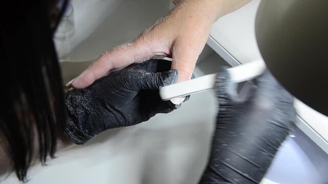 Manicurist Shaping Fingernails with Nail File Close Up