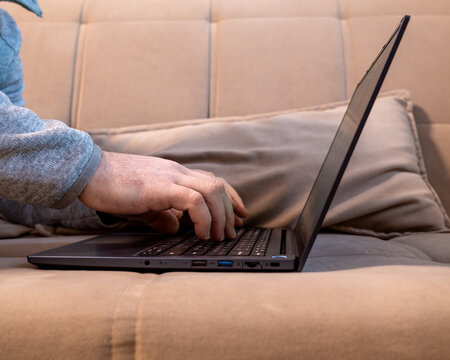 Close-up of hands using a laptop touchpad, modern work.