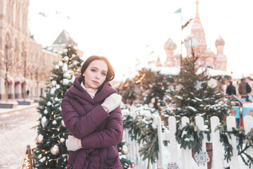 Woman on a street during Christmas in Moscow, wearing winter clothing and looking to the side. Travel concept. © Анна Маркина