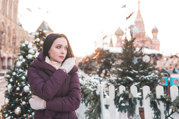 Woman on a street during Christmas in Moscow, wearing winter clothing and looking to the side. Travel concept. © Анна Маркина