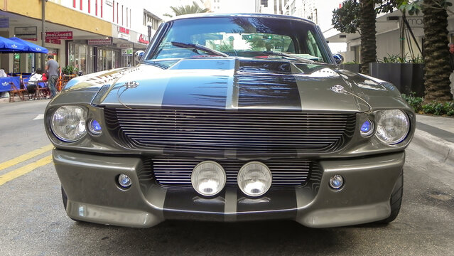 A symmetrical low-angle front view of a classic 1967 Ford Mustang Shelby GT500 Eleanor tribute car. 
