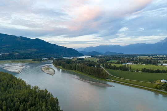 Aerial View Of Serene Fraser River Valley At Sunset With Mountains And Farmland Near Chilliwack, British Columbia