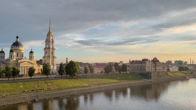 Picturesque riverside promenade at warm summer sunset. Golden light above Volga river in beautiful old town