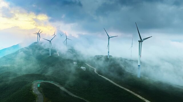 Misty mountain wind farm with turbines and winding access roads under layered clouds, illustrating renewable energy, clean technology, and sustainable infrastructure.