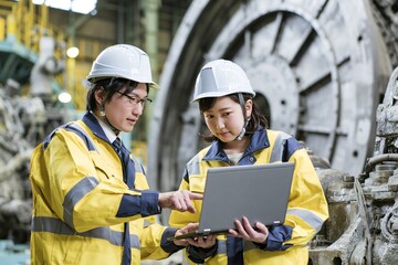 Fototapeta premium 製造工場現場でノートPC確認する日本人若い男女技術者