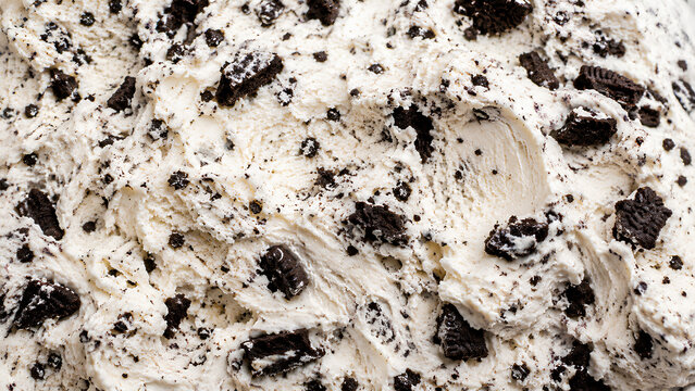 Close-up macro texture of creamy cookies and cream ice cream with abundant chocolate cookie chunks and crumbs. Perfect food background for menus, packaging and dessert advertising.