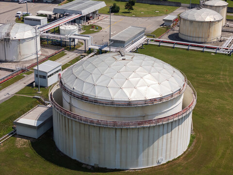 This aerial view shows a petroleum storage terminal featuring large fuel tanks and industrial facilities for oil distribution.