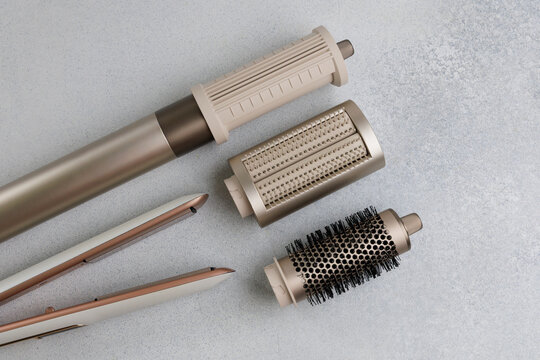 Various hair styling tools arranged on a smooth surface showing different components and designs