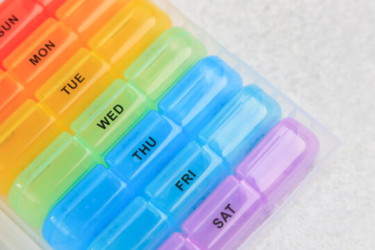 Colorful weekly pill organizer on a white surface for easy medication management