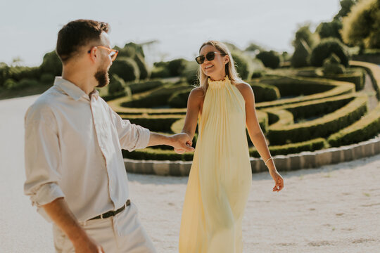 Couple enjoys a sunny stroll in a beautifully landscaped garden