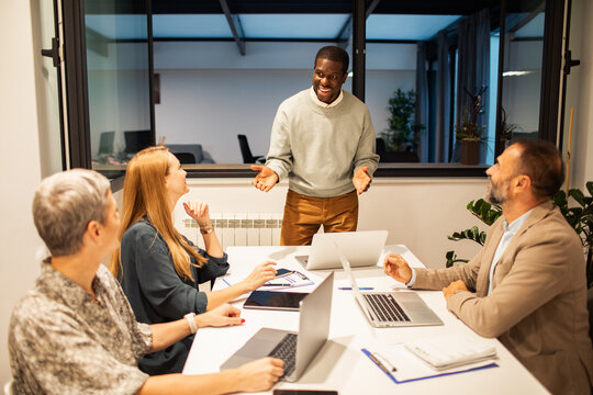 Team leader presenting to colleagues in modern office
