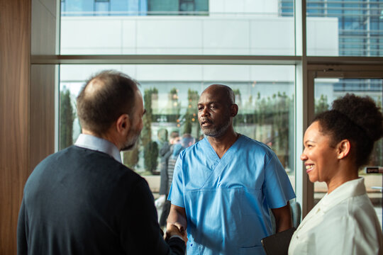 Healthcare professionals greeting visitor in hospital lobby
