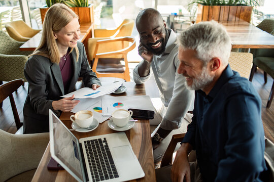 Business colleagues reviewing charts at coffee shop