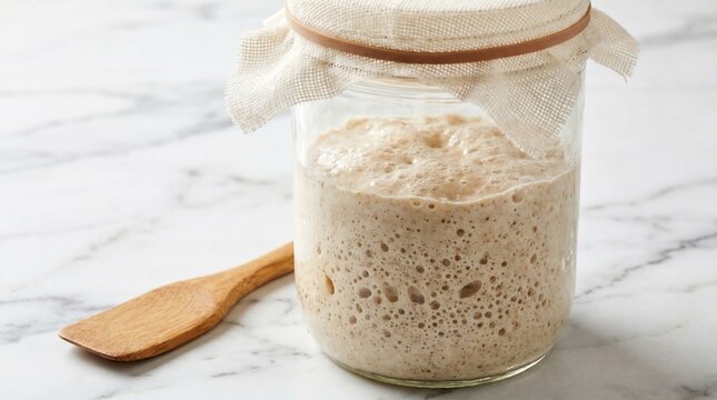 Active bubbling sourdough starter in a glass jar ready for bread making